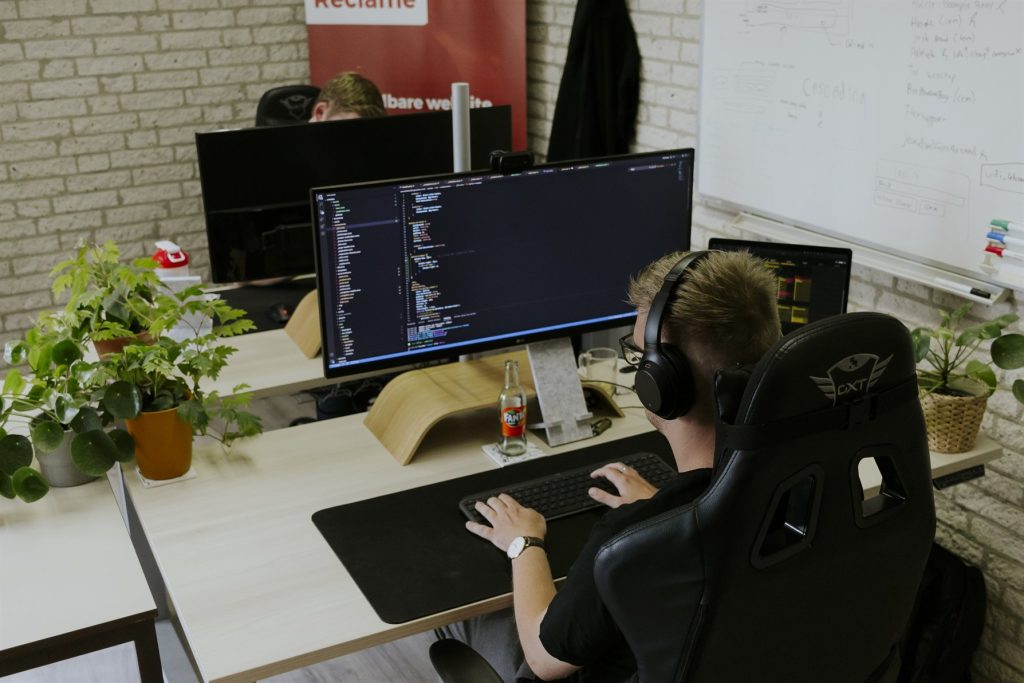 Developer with headphones coding at the office in Kollum