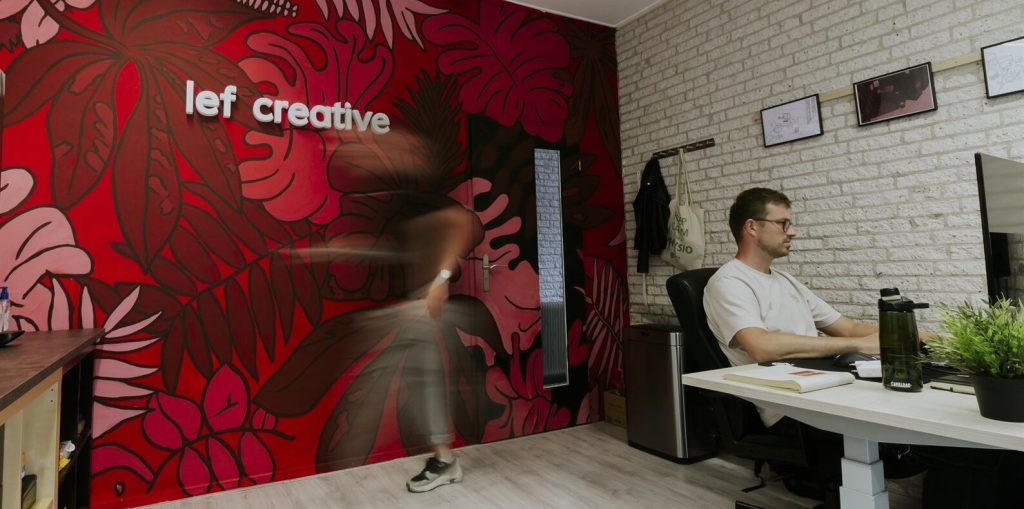 Lef Creative office with the logo on the wall and developers at work