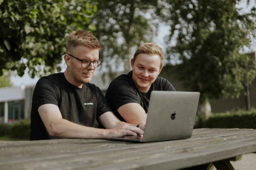 Two Lef Creative team members working together on a laptop